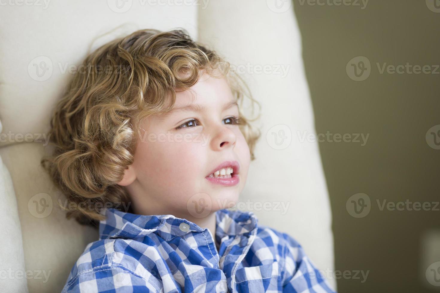 Cute Blonde Boy Daydreaming and Sitting in Chair photo