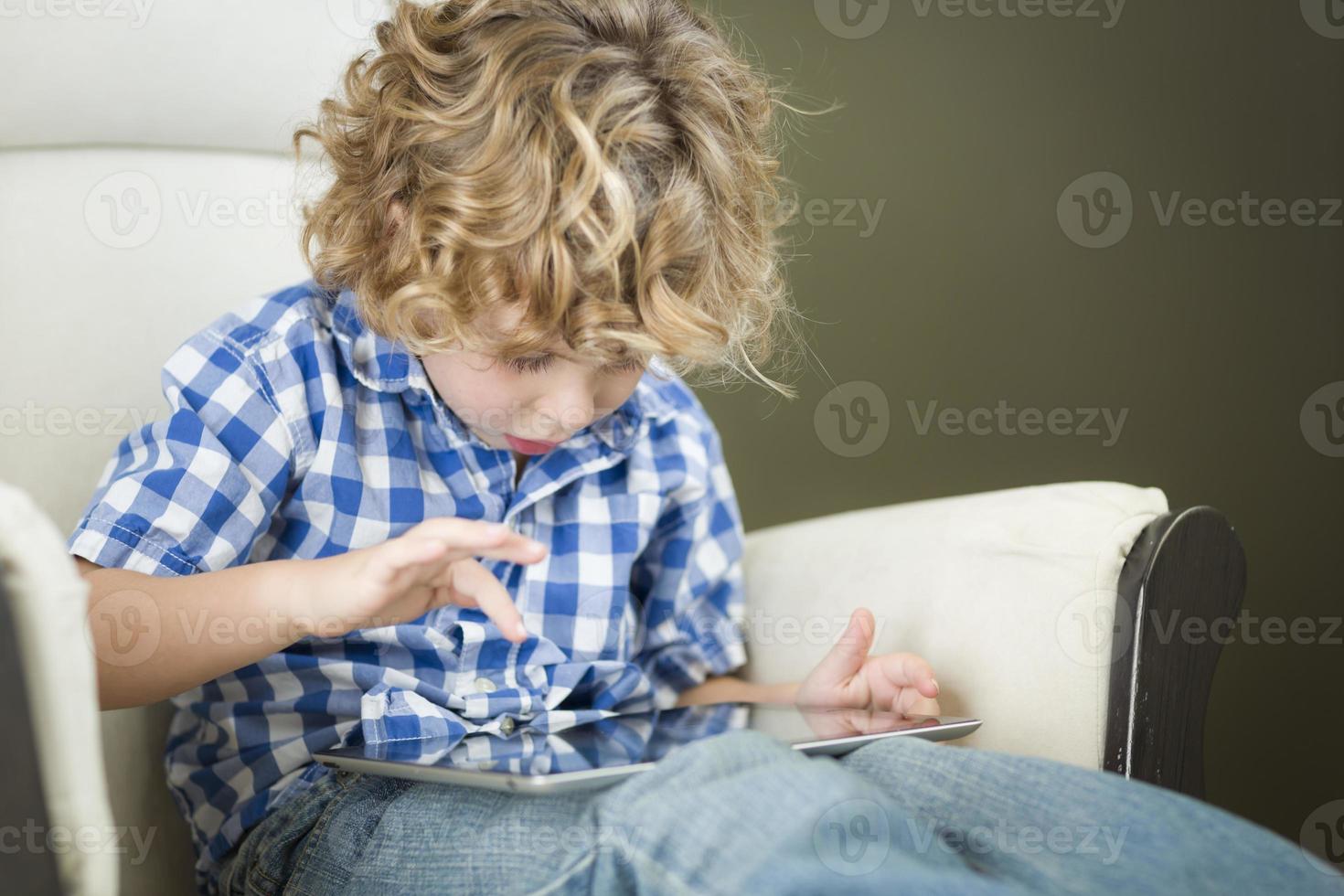 Young Blond Boy Using His Computer Tablet photo