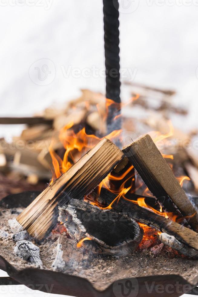 leña ardiendo dentro del pozo de fuego durante el frío día de invierno foto
