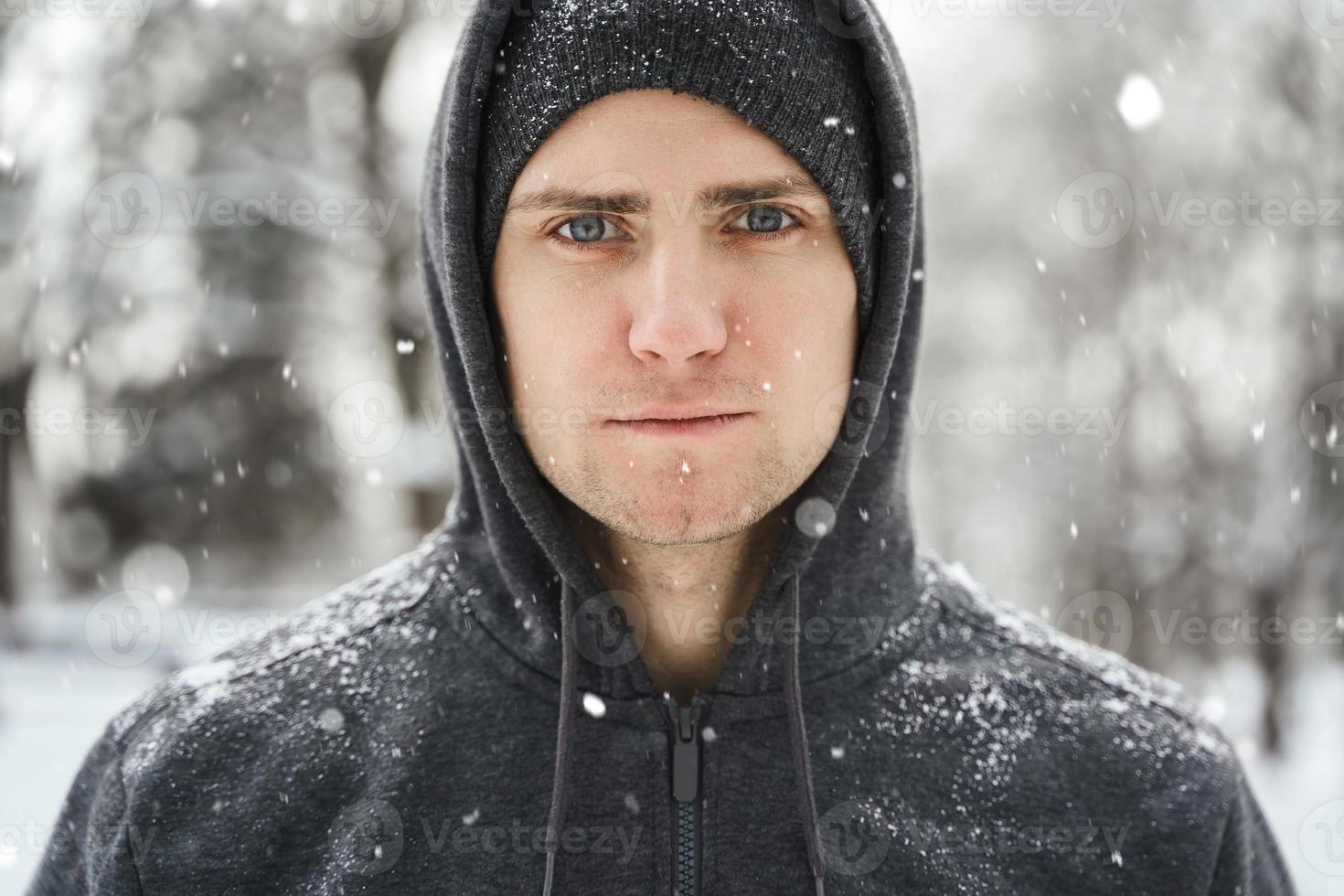 hombre atlético guapo con capucha durante su entrenamiento de invierno foto