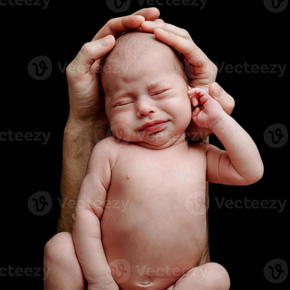 Funny newborn baby in the father's hands photo