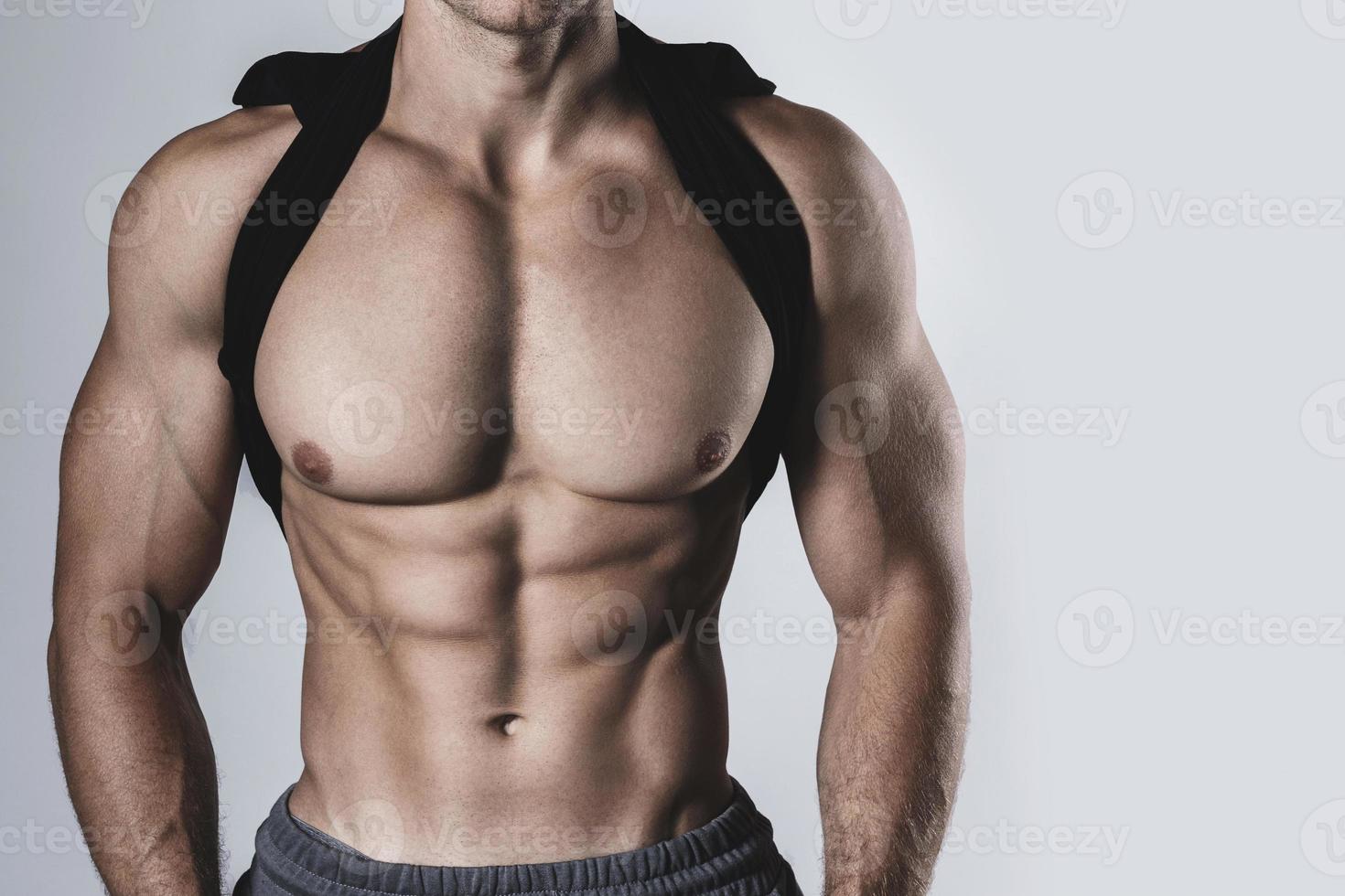 Bodybuilder with a muscular body on gray background photo