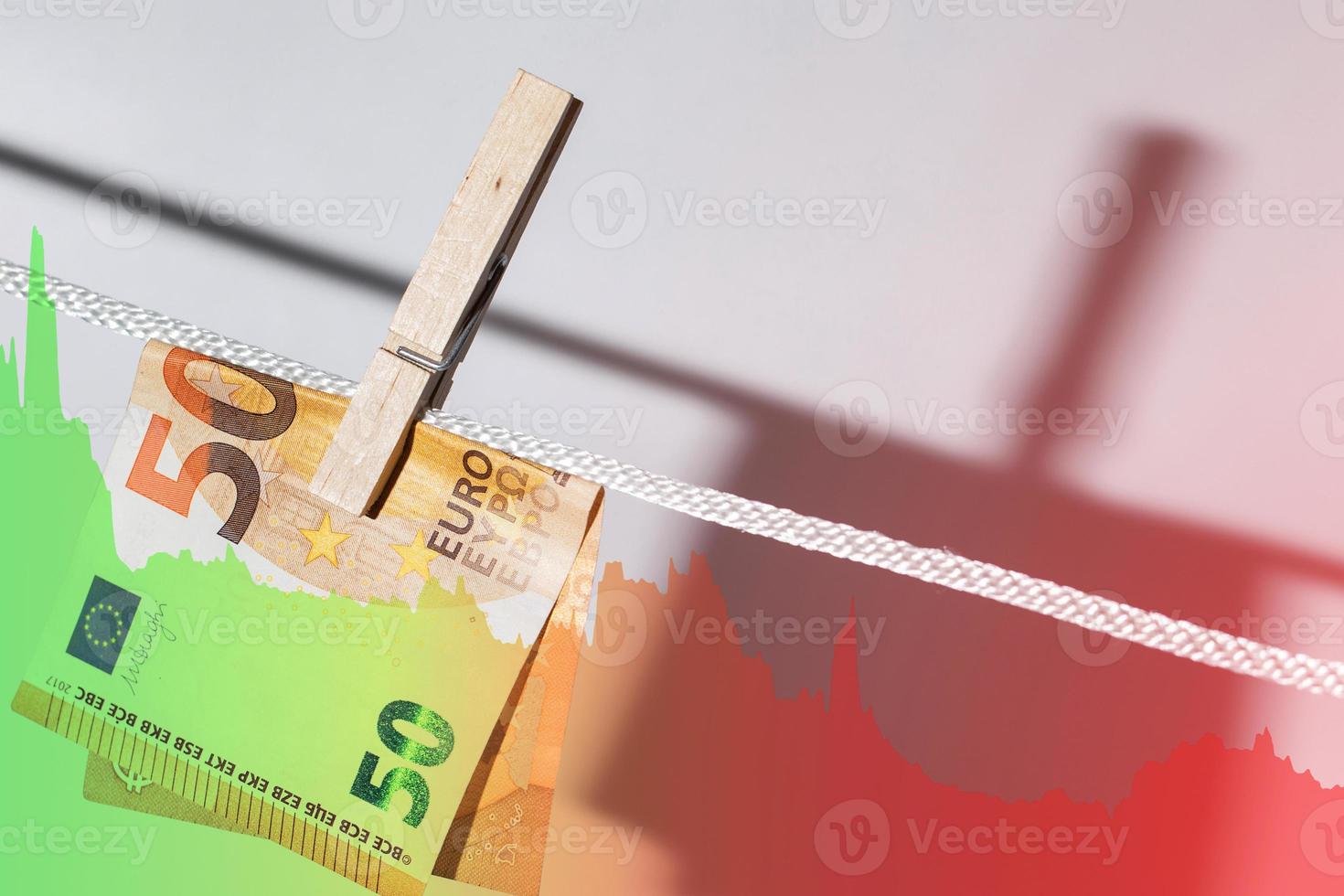 Euro banknote hung on a rope with clothespin and falling diagram chart photo