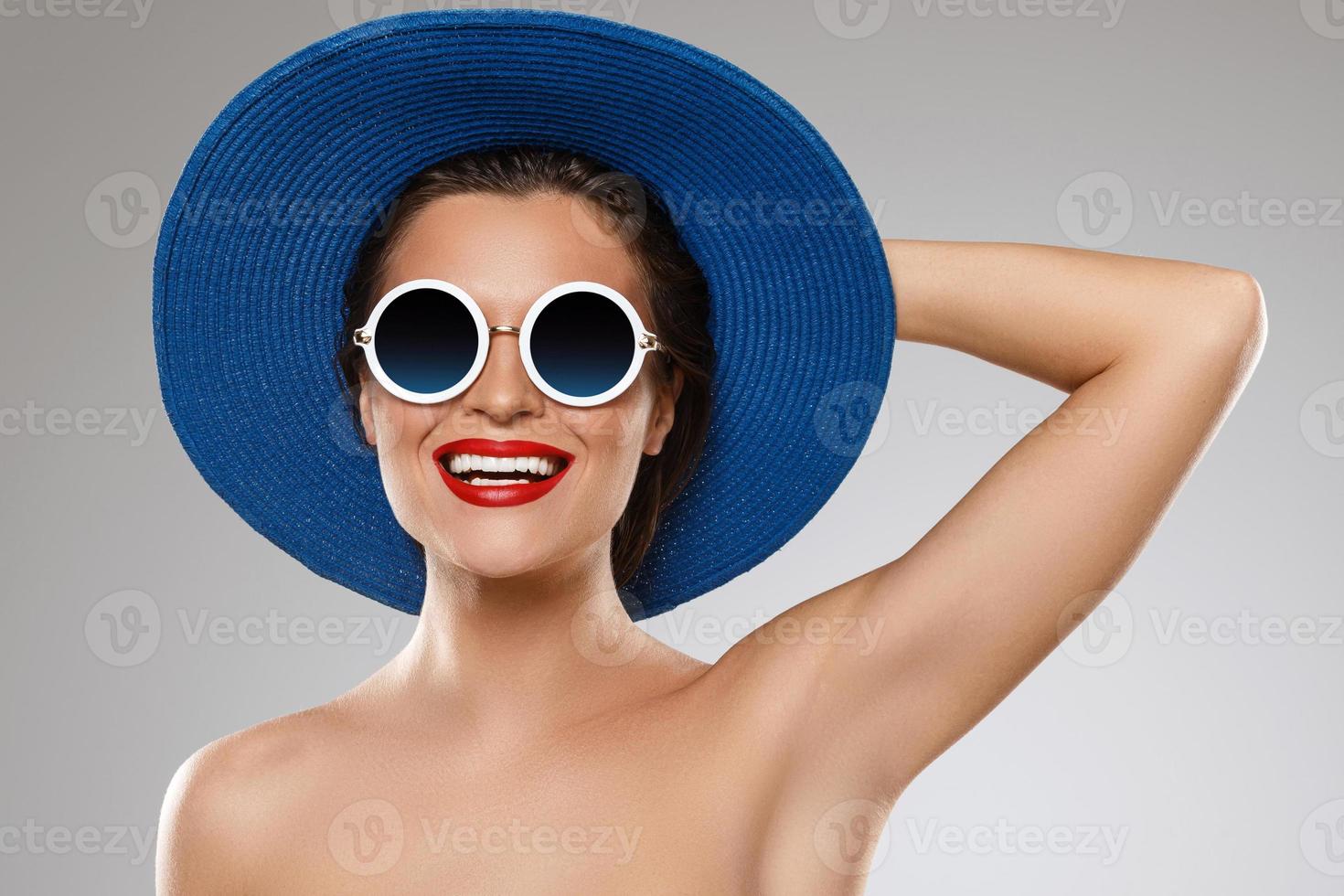 Beautiful woman wearing blue hat and sunglasses is ready for vacation photo