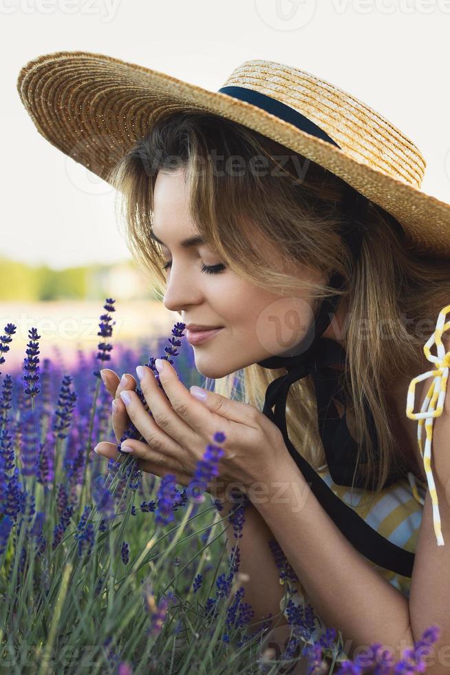 Beautiful young woman in a field full of lavender flowers photo