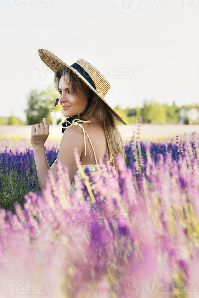 Beautiful young woman in a field full of lavender flowers photo