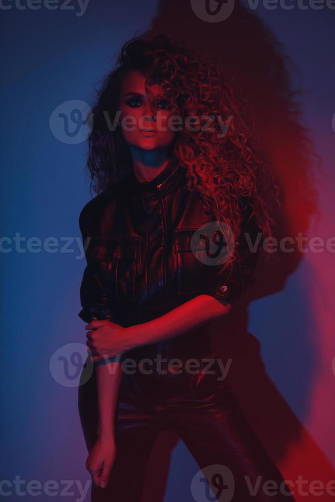 mujer joven y sexy con un elegante peinado afro con traje de motociclista de cuero foto