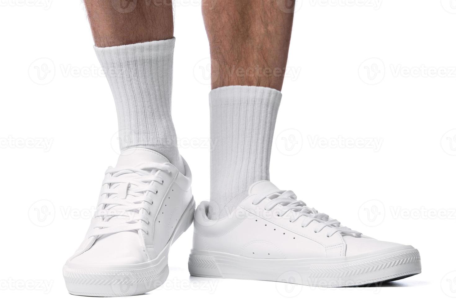 Closeup of male feet and shoes. Man wearing white trainers on white background. photo