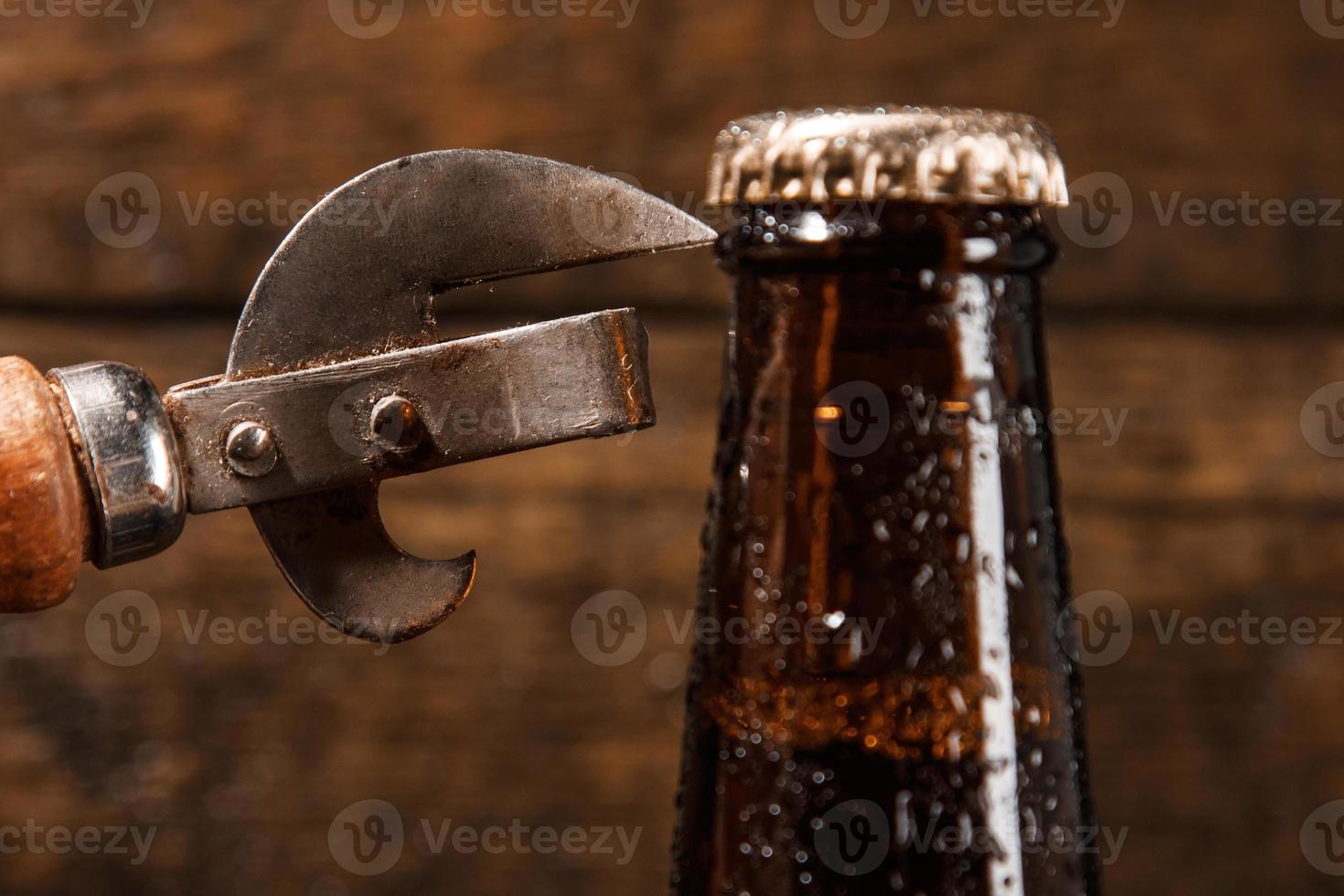 Bottle of beer and vintage opener photo