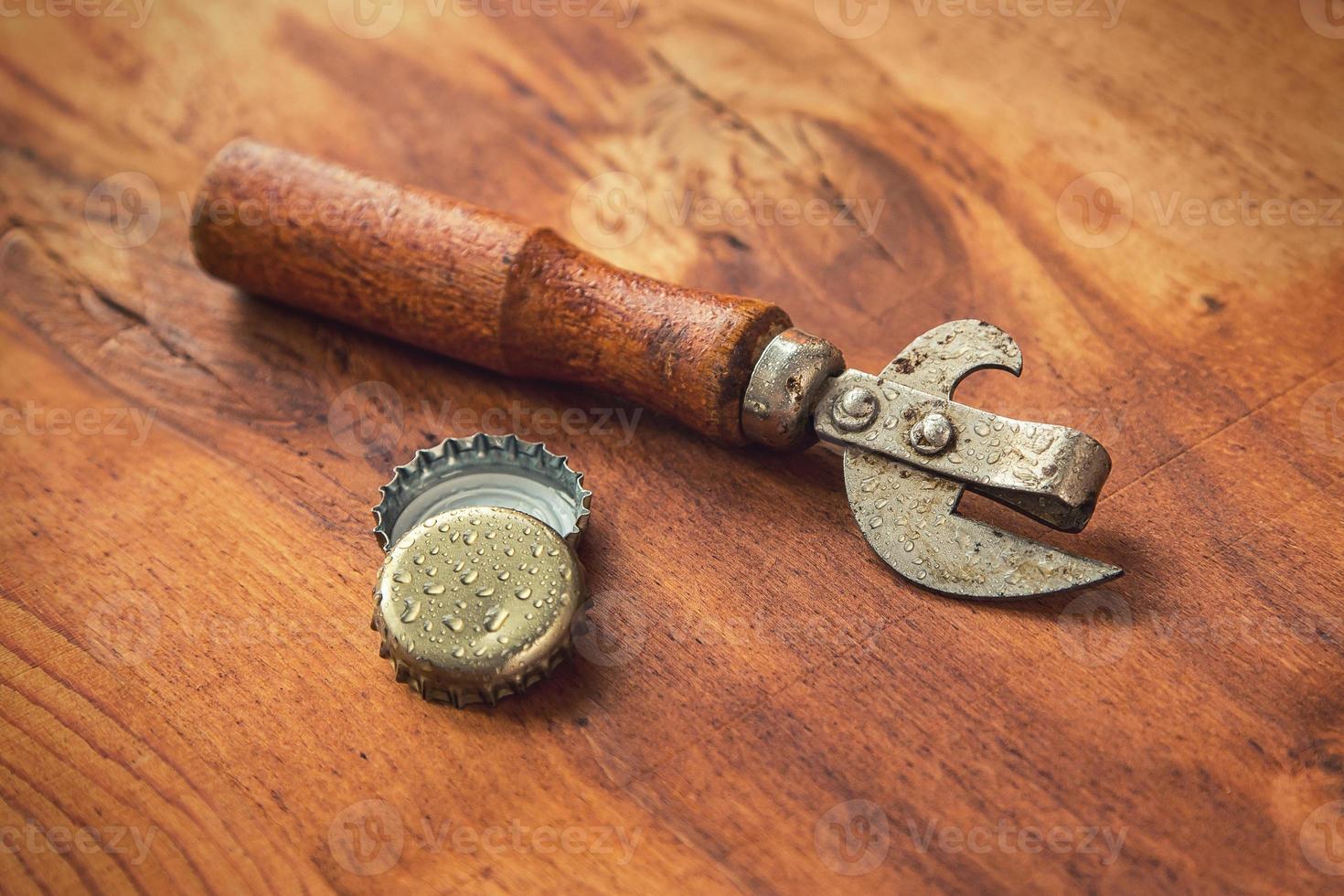 Old opener tool and beer caps photo