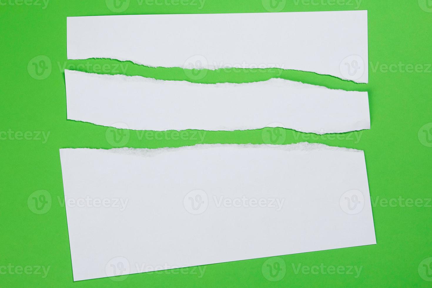 Torn paper on green background photo