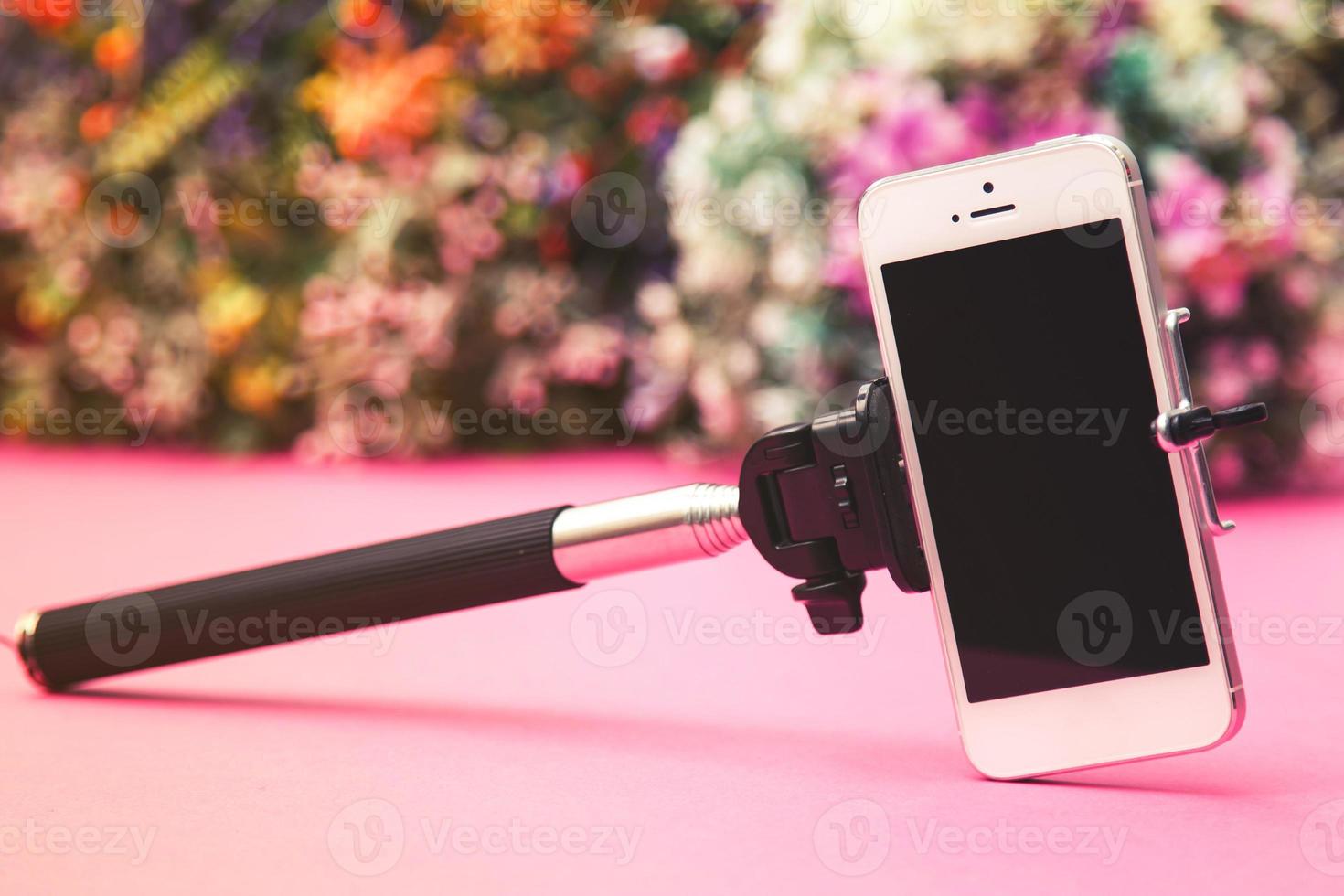 Selfie stick on background with flowers photo