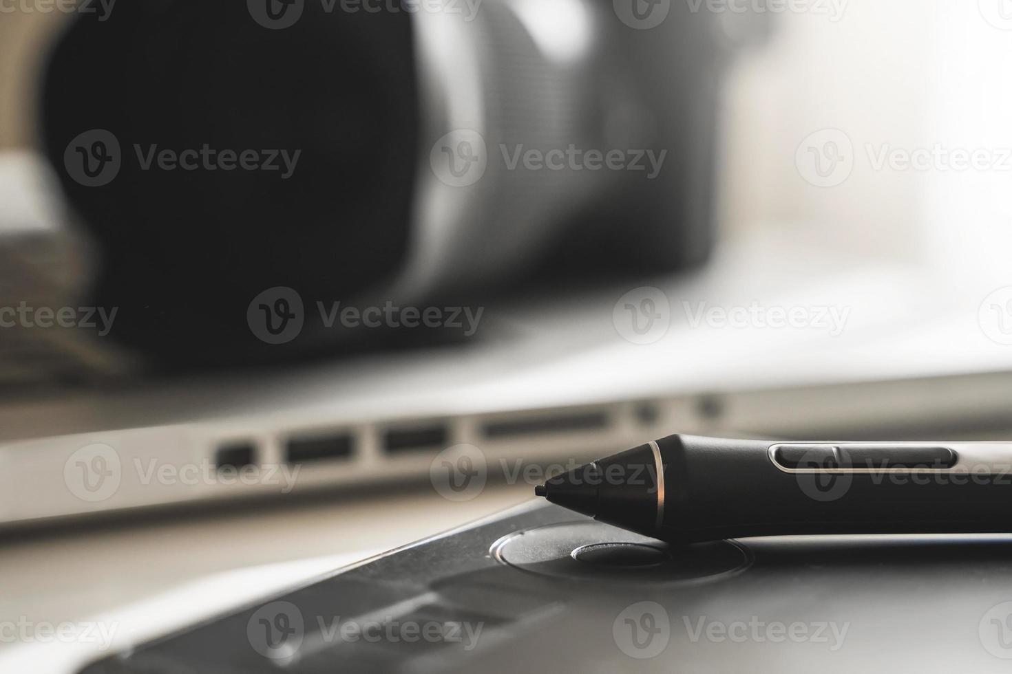 Photographer's workplace with a mirrorless camera, laptop and graphics tablet photo