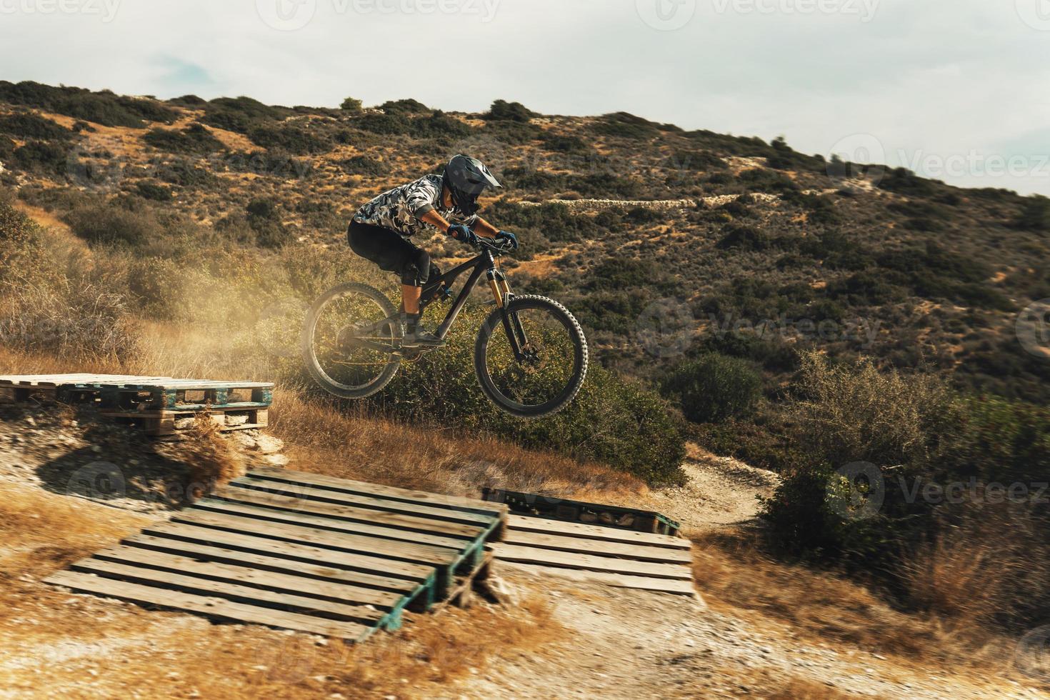 ciclista de mtb saltando durante un paseo cuesta abajo en su bicicleta en las montañas foto