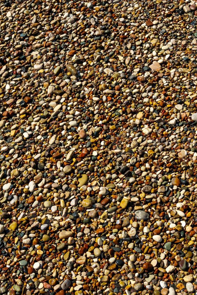 fondo de piedras de guijarros en la playa foto