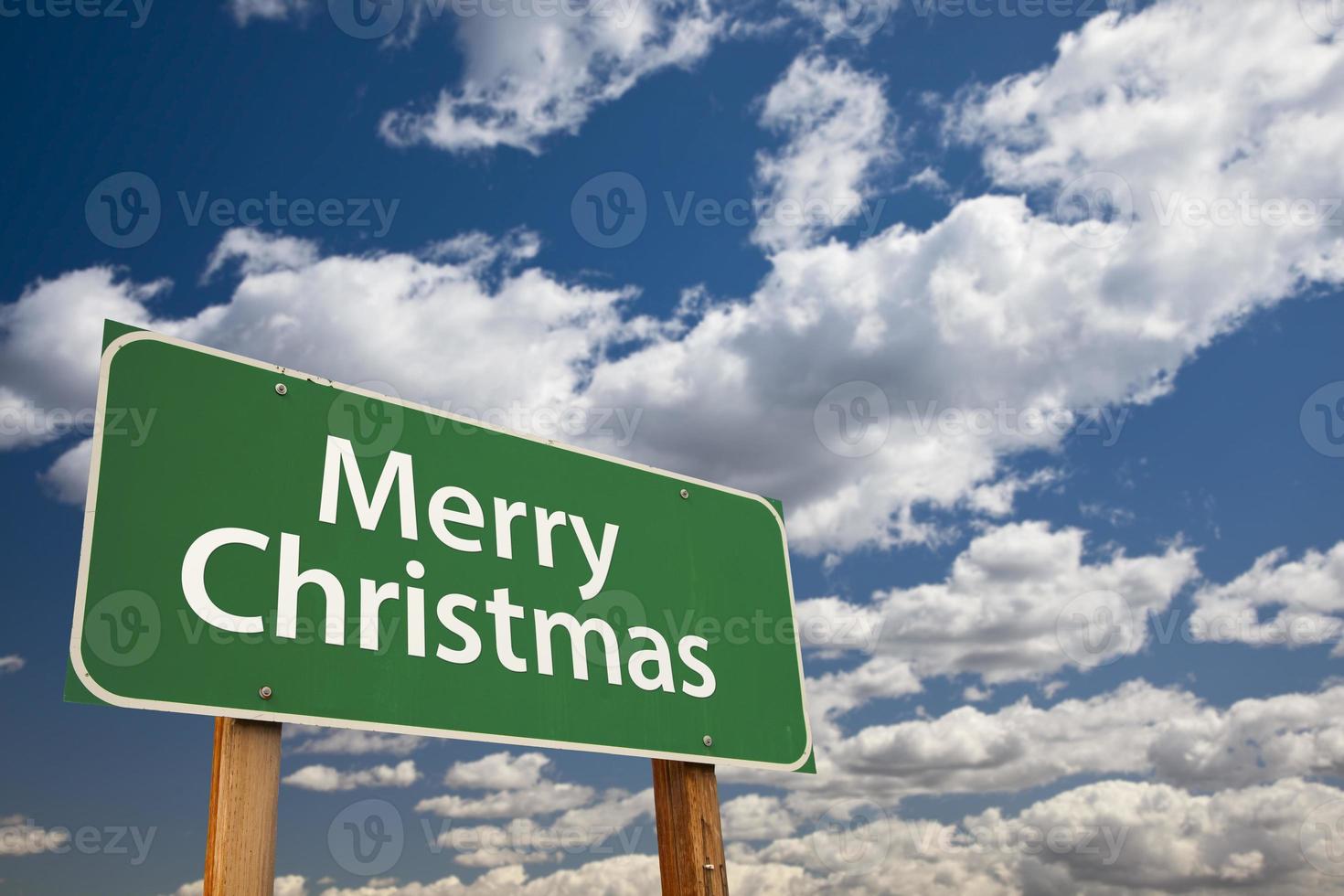 Merry Christmas Green Road Sign Over Clouds and Sky photo