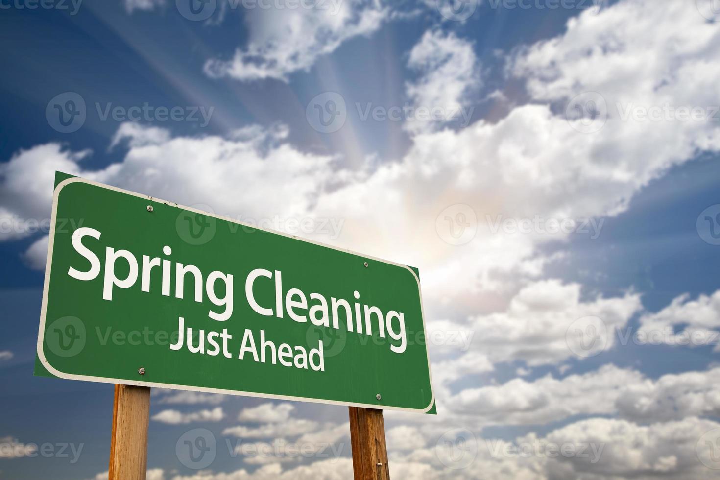 Spring Cleaning Just Ahead Green Road Sign and Clouds photo