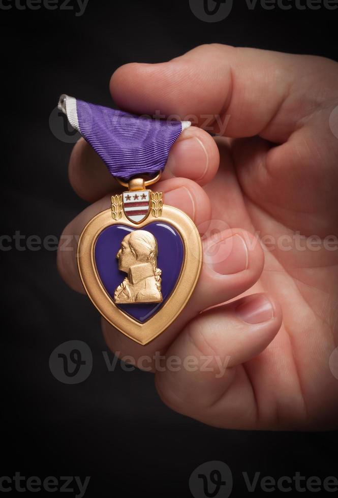 Male Hand Holding the Armed Forces Purple Heart Metal photo