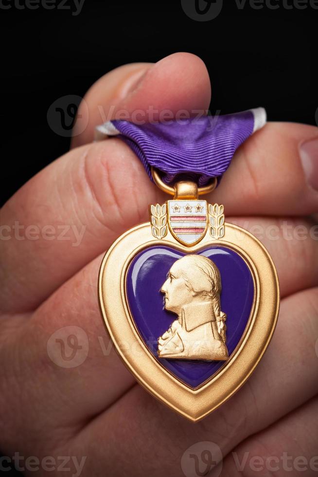 Male Hand Holding the Armed Forces Purple Heart Metal photo