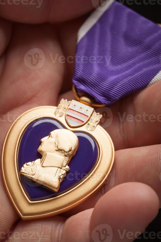 Male Hand Holding the Armed Forces Purple Heart Metal photo