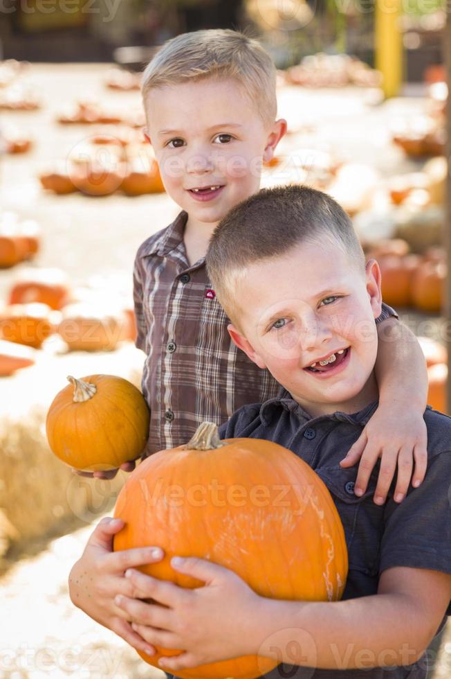 Two Boys Having Fun at the Pumpkin Patch on a Fall Day. photo