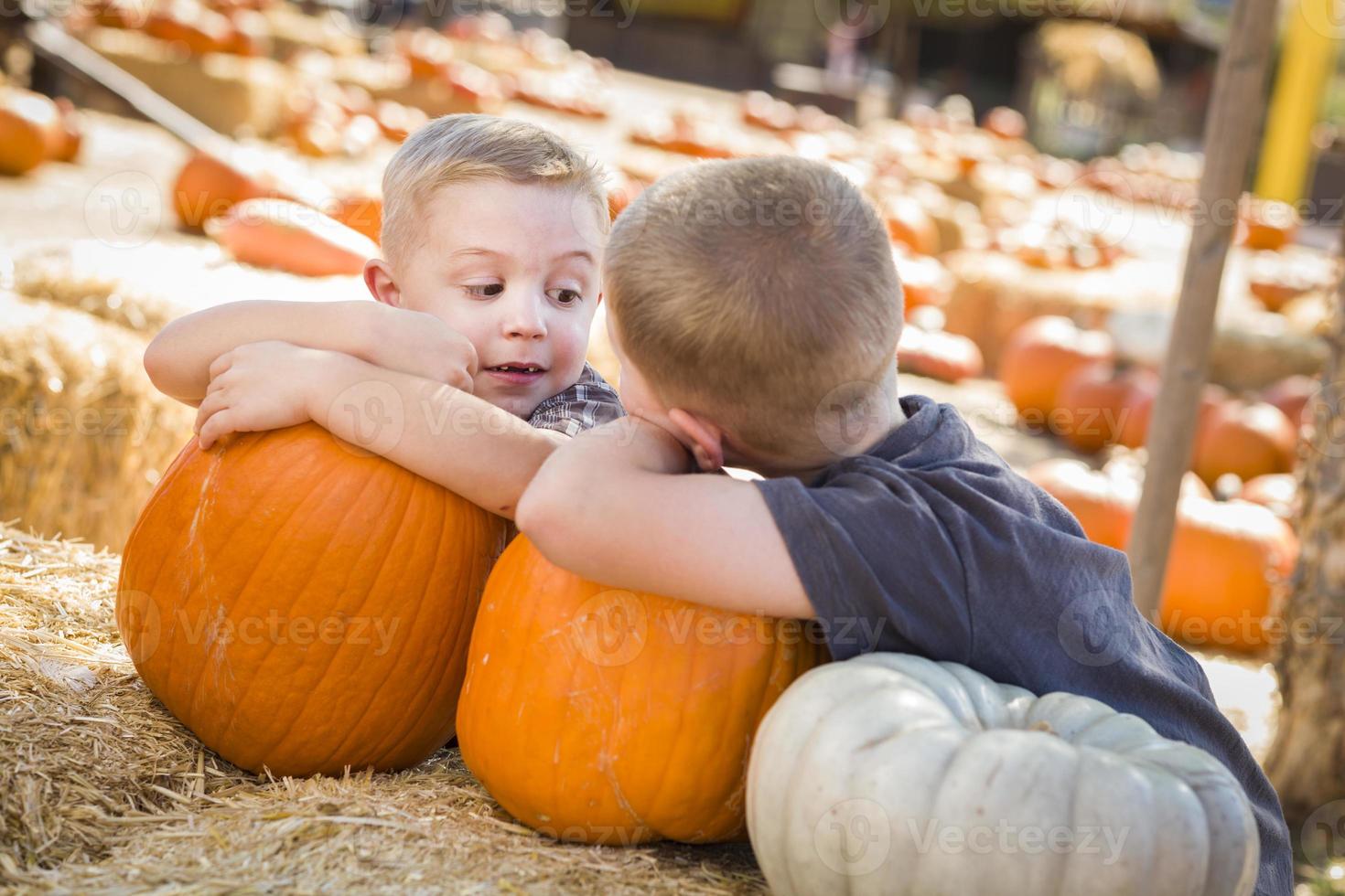 Two Boys Having Fun at the Pumpkin Patch on a Fall Day. photo