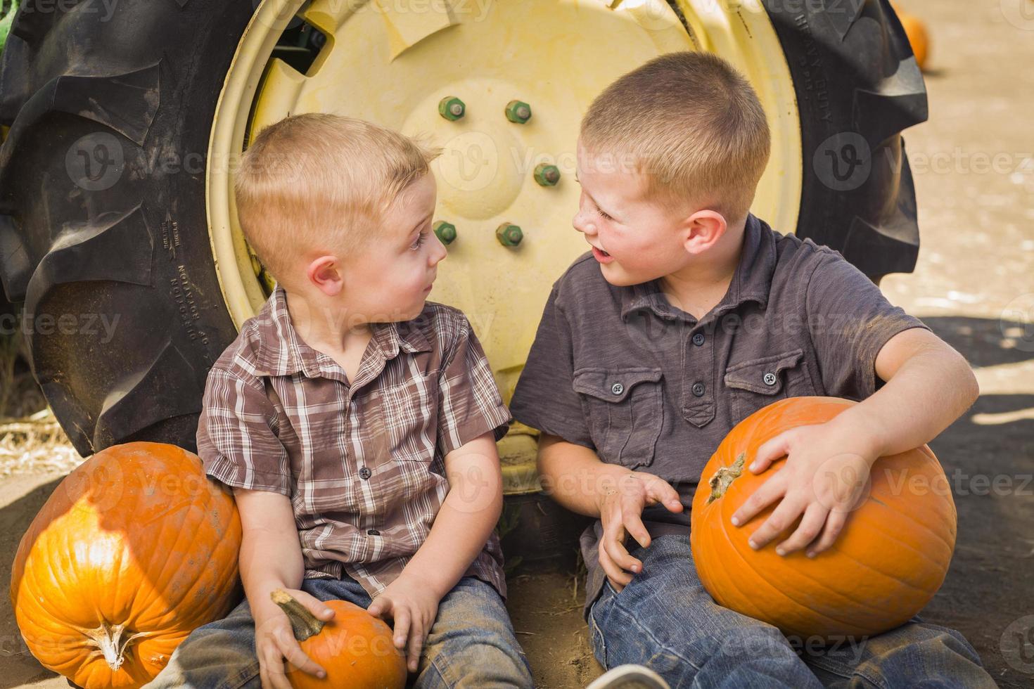 Two Boys Having Fun at the Pumpkin Patch on a Fall Day. photo