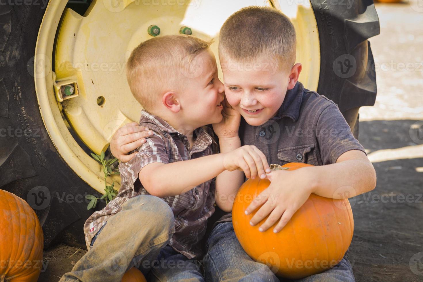 Two Boys Having Fun at the Pumpkin Patch on a Fall Day. photo