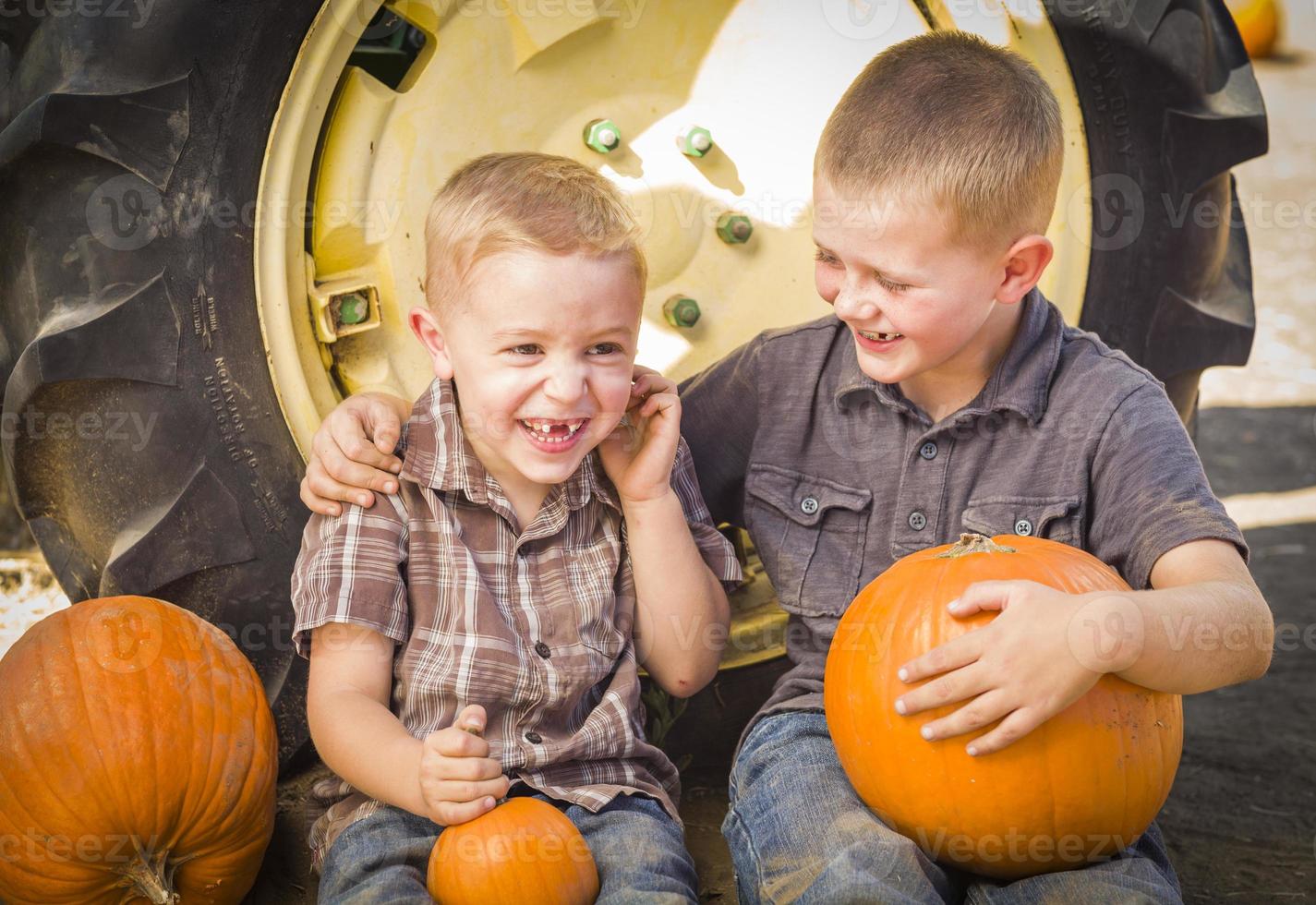 Two Boys Having Fun at the Pumpkin Patch on a Fall Day. photo