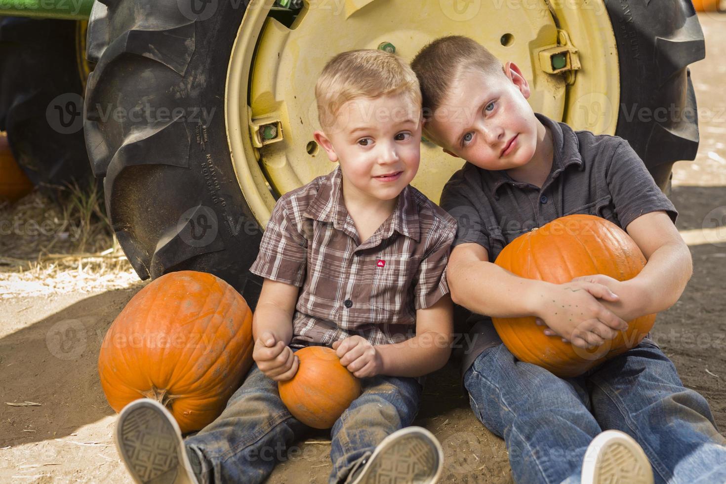 Two Boys Having Fun at the Pumpkin Patch on a Fall Day. photo