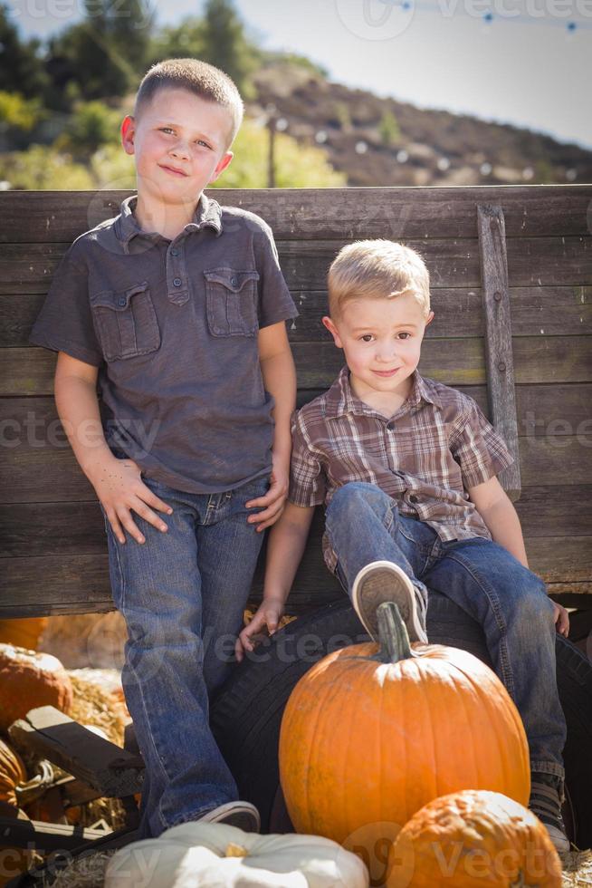 Two Boys Having Fun at the Pumpkin Patch on a Fall Day. photo