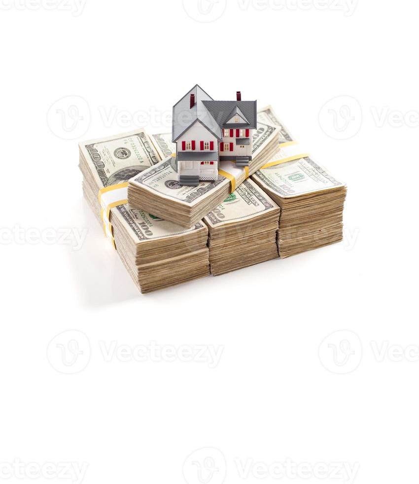 Small House on Stacks of Hundred Dollar Bills Isolated on a White Background photo