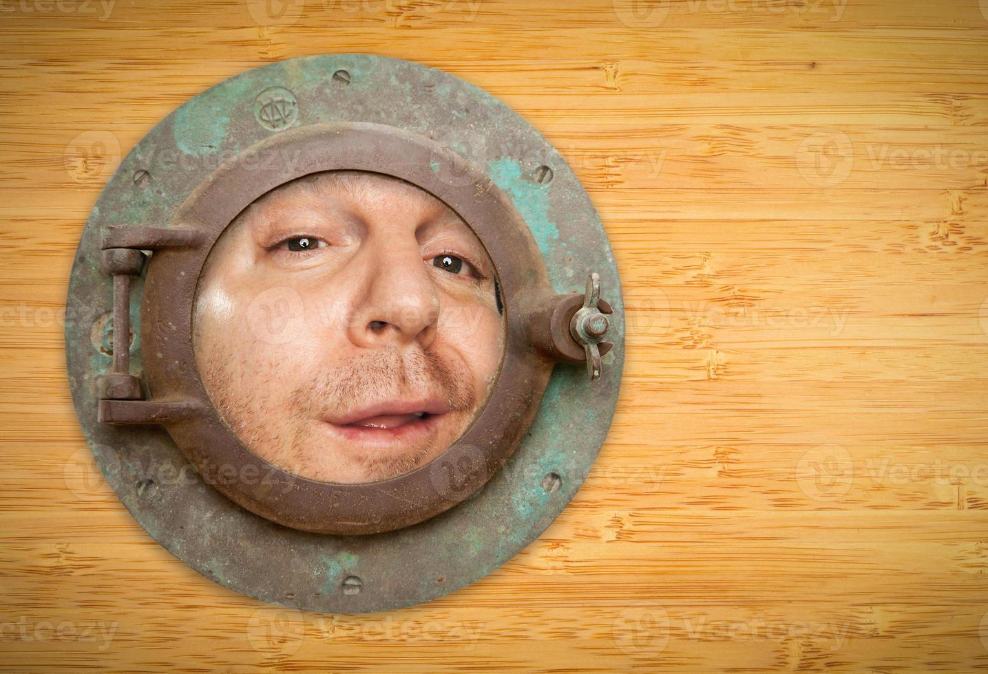 Antique Porthole on Bamboo Wall with Funky Man Looking Through photo