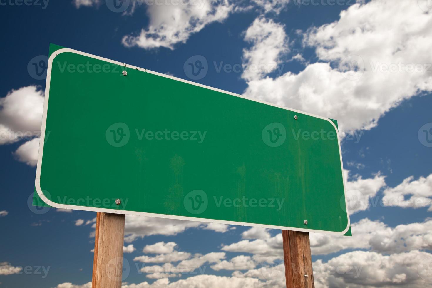 Blank Green Road Sign Over Clouds photo