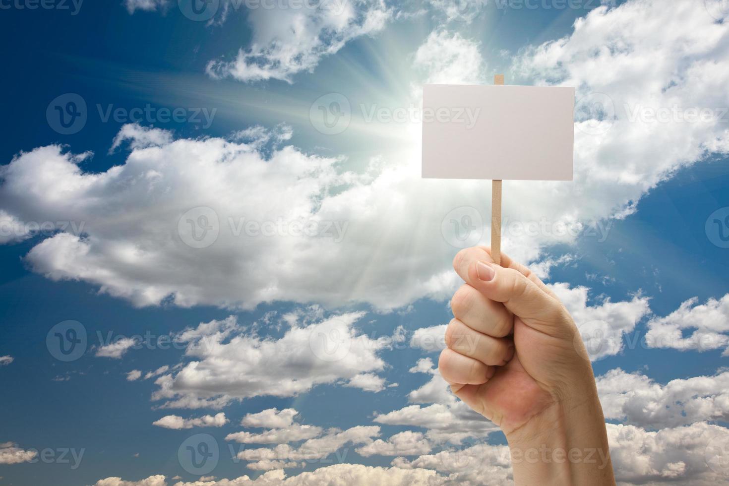 Man Holding Blank Sign Over Clouds and Sky photo