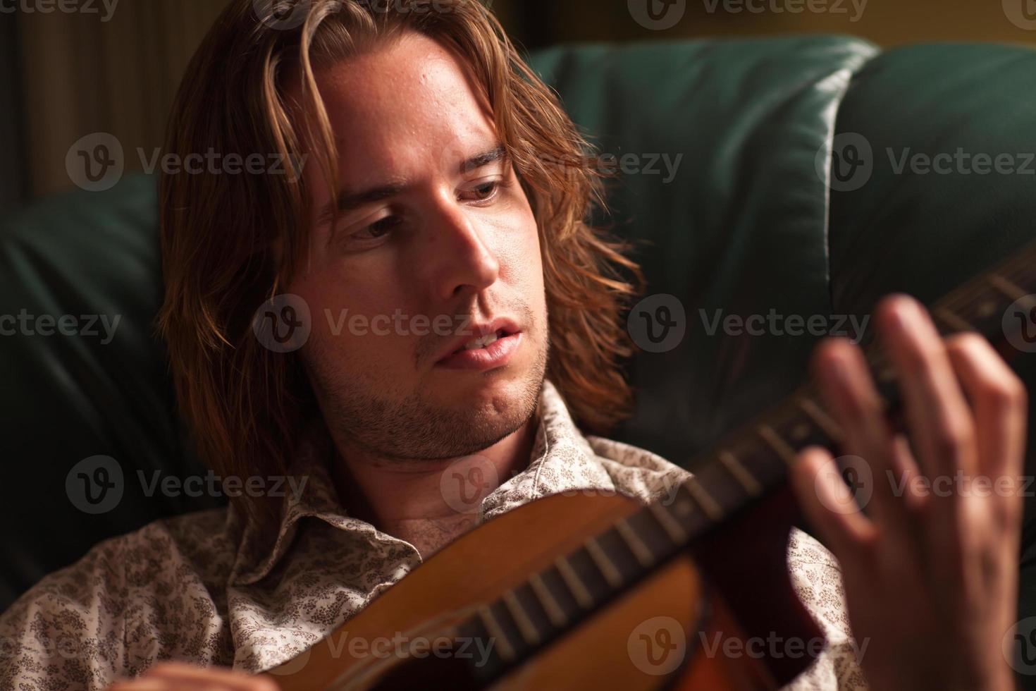 Young Musician Plays His Acoustic Guitar photo