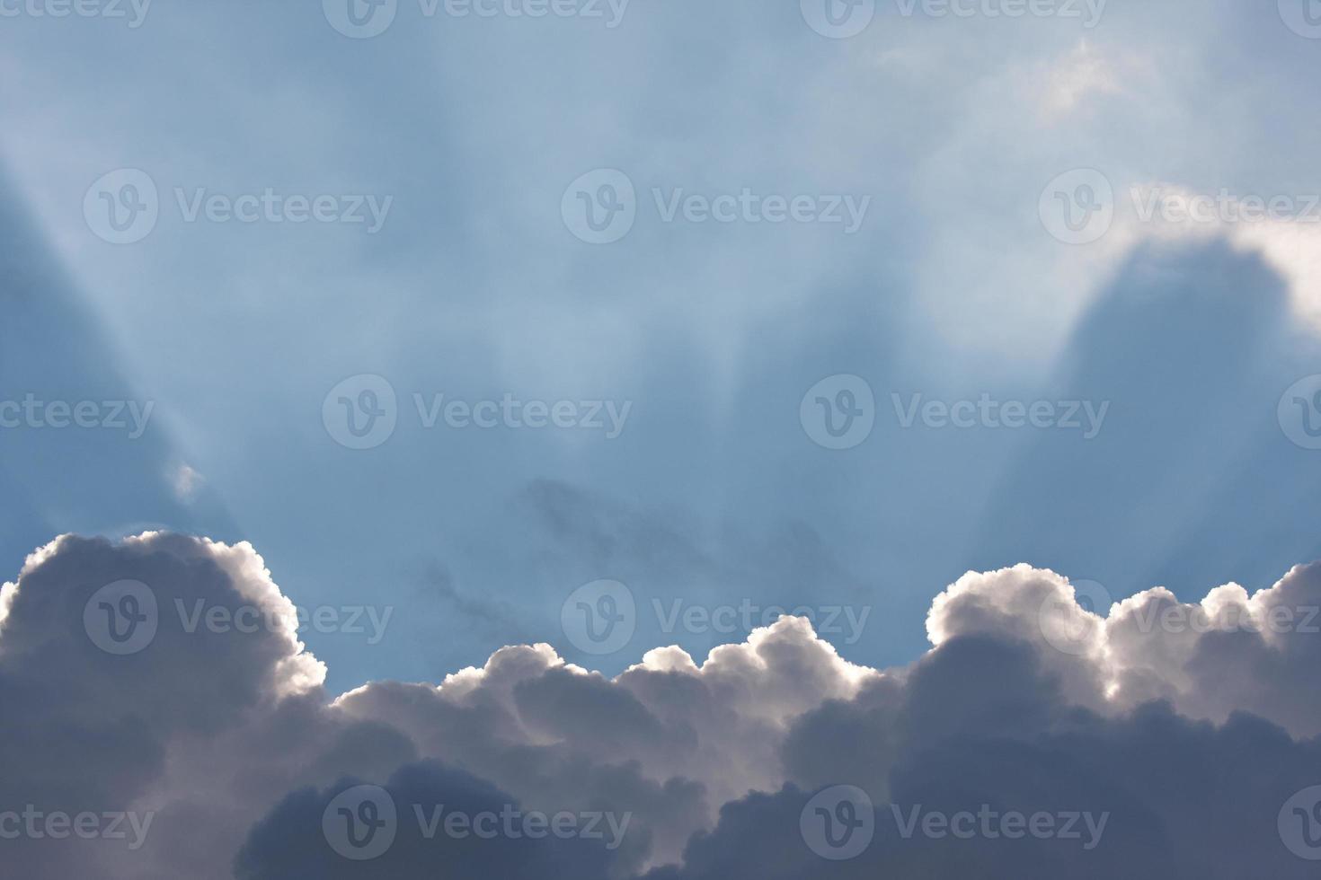 cielo azul con nubes y rayos de sol foto