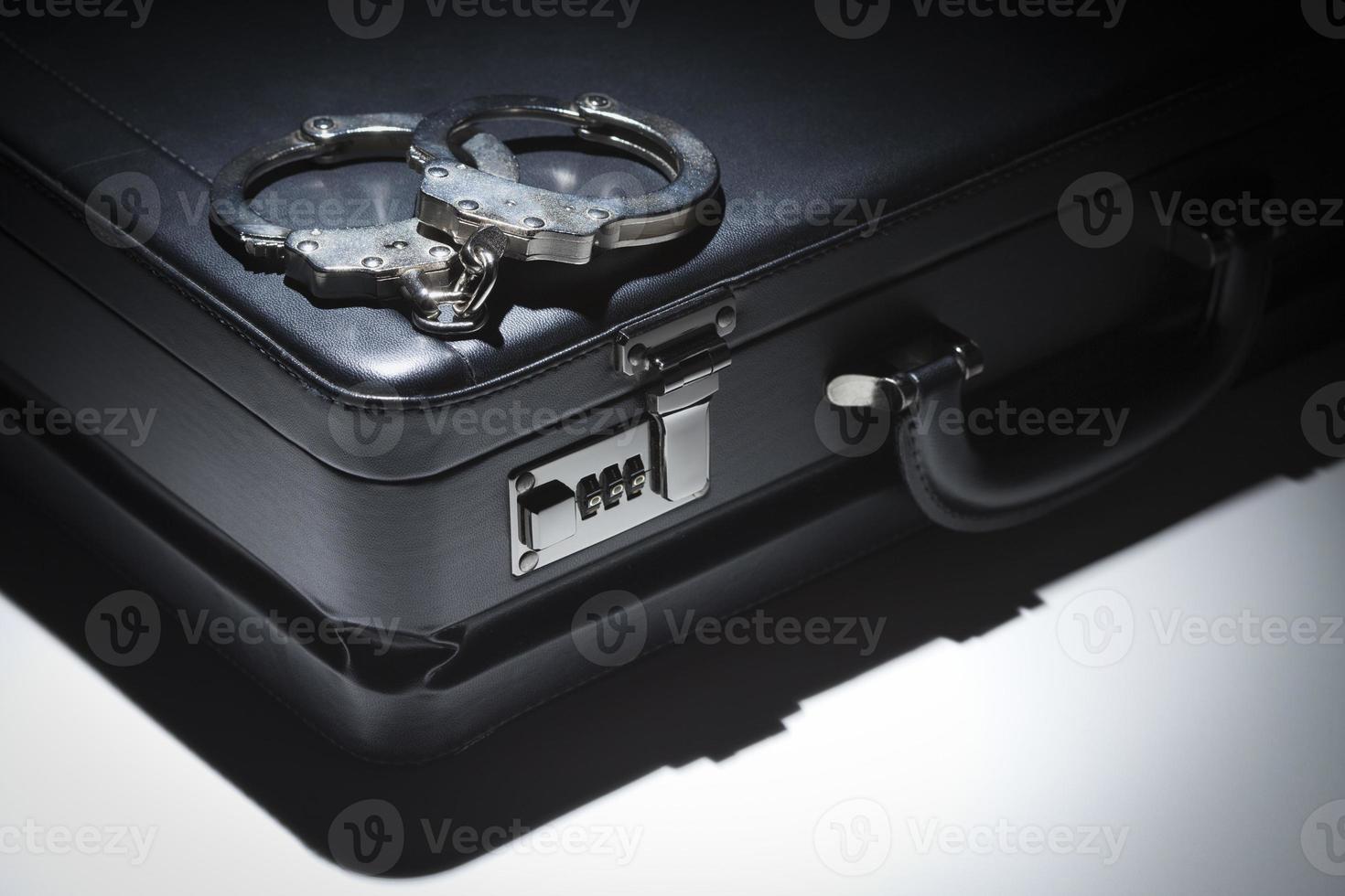 Pair of Handcuffs and Briefcase Under Spot Light photo