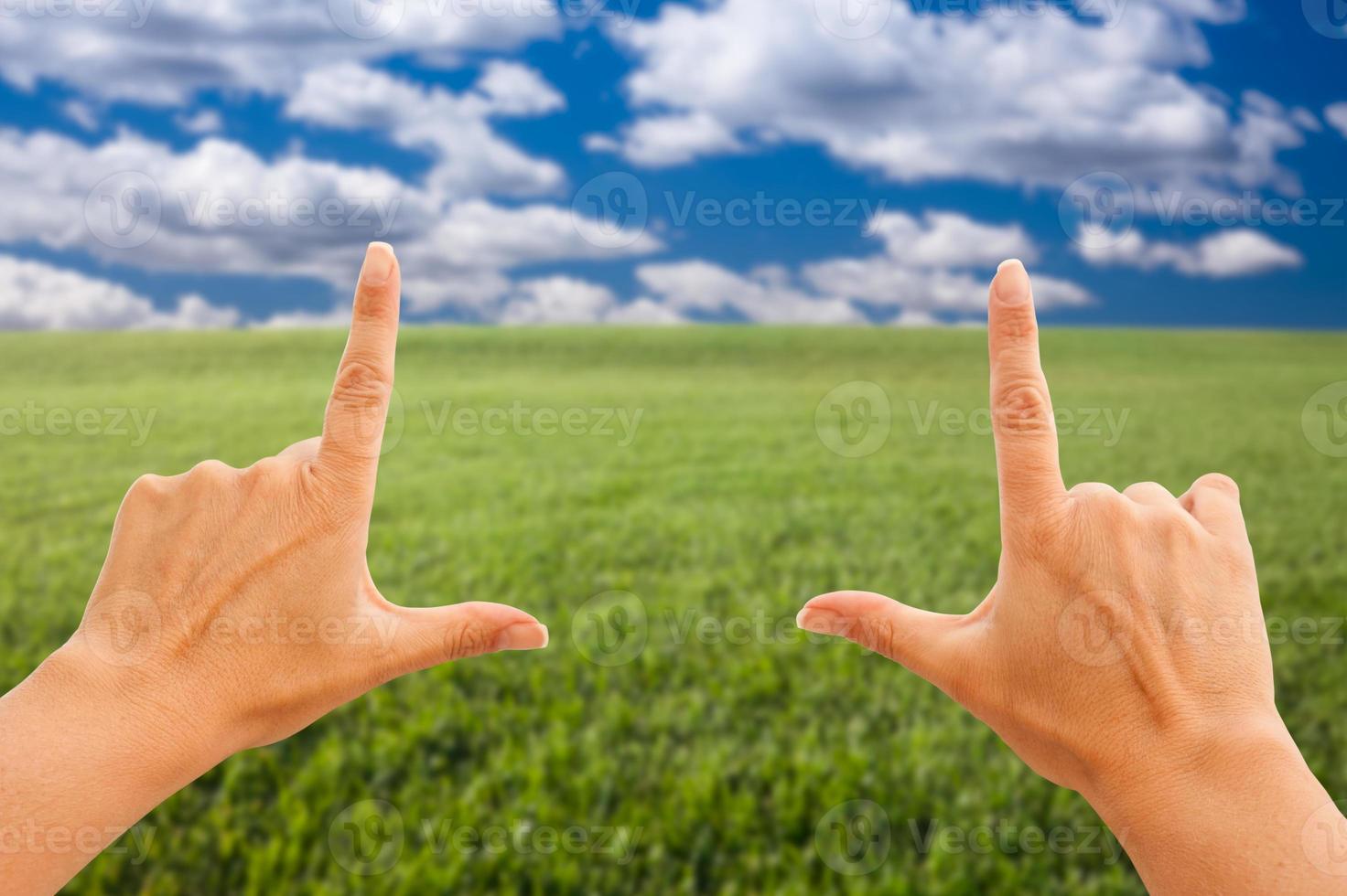 manos femeninas haciendo un marco sobre hierba y cielo foto