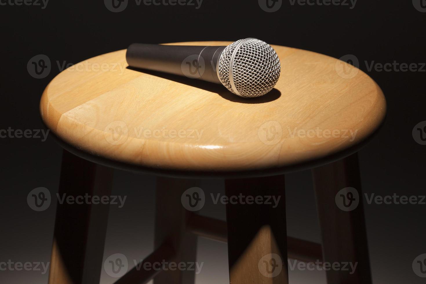 Microphone Laying on Wooden Stool Under Spotlight photo