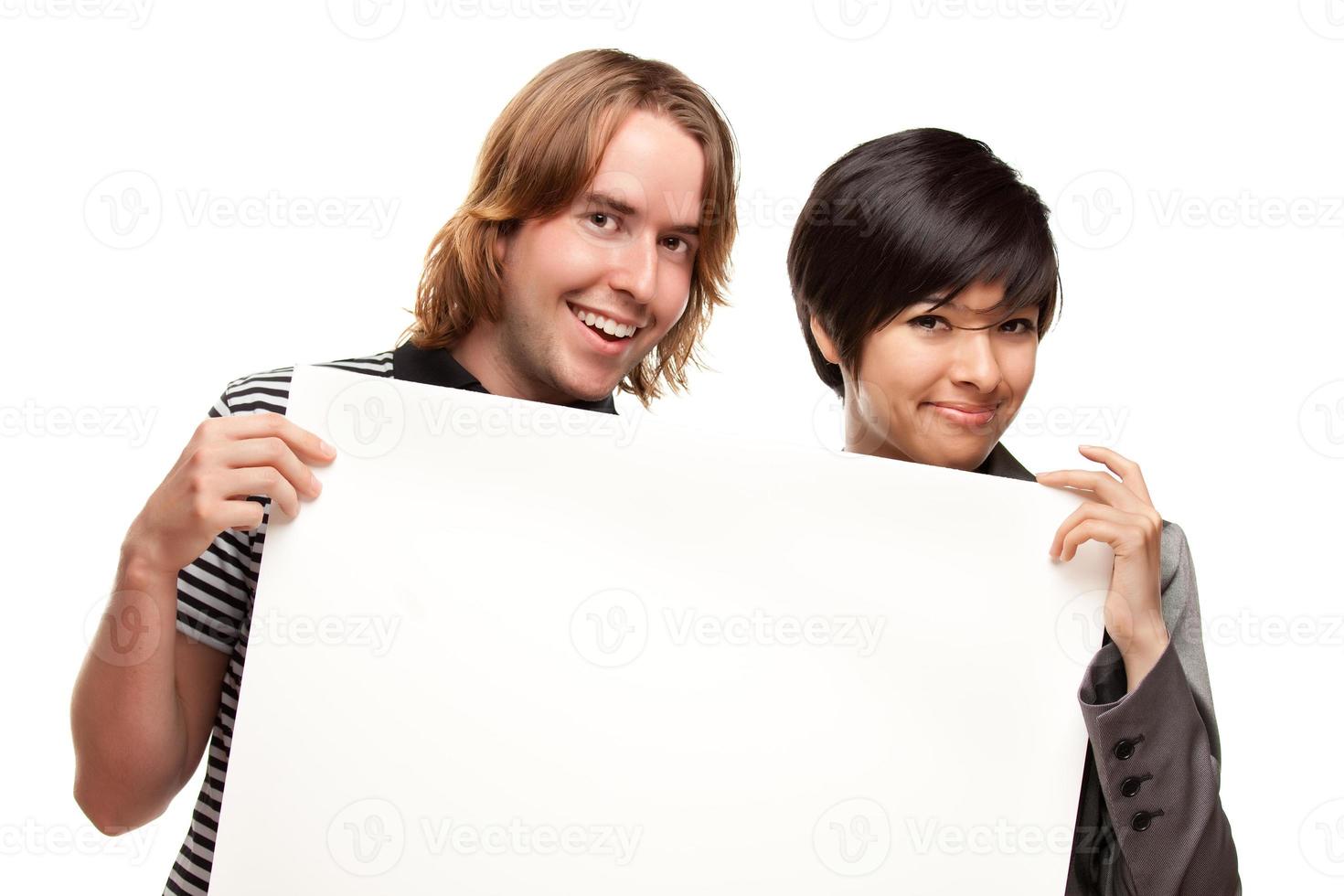 atractiva pareja diversa con cartel en blanco foto