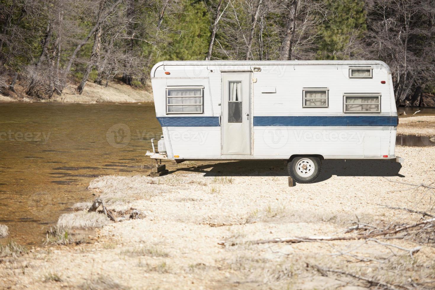 Remolque de camper antiguo clásico cerca de un río foto