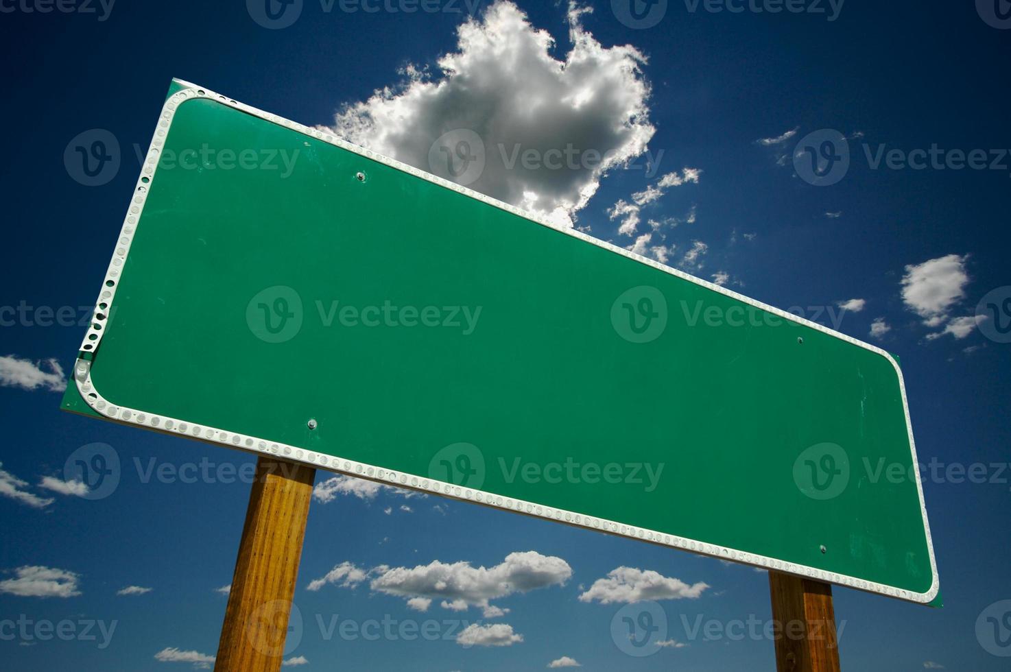 Blank Green Road Sign Over Clouds photo