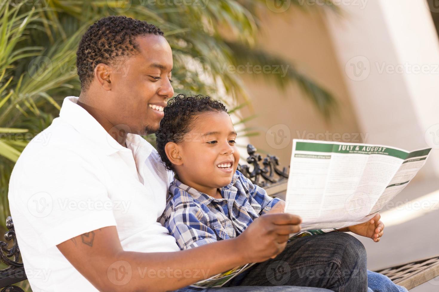 Mixed Race Father and Son Reading Park Brochure Outside photo