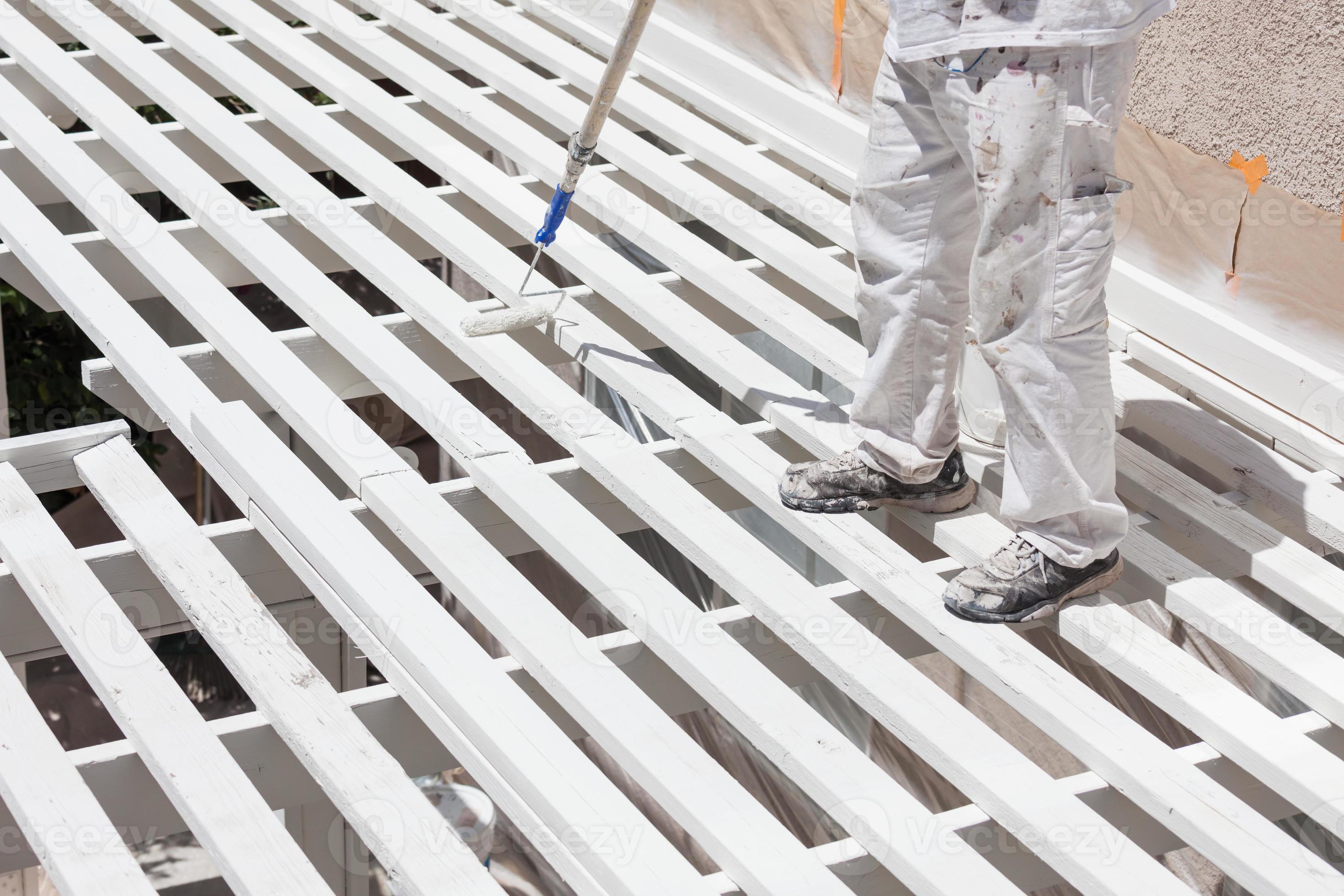 Professional Painter Rolling White Paint Onto The Top of A Home Patio