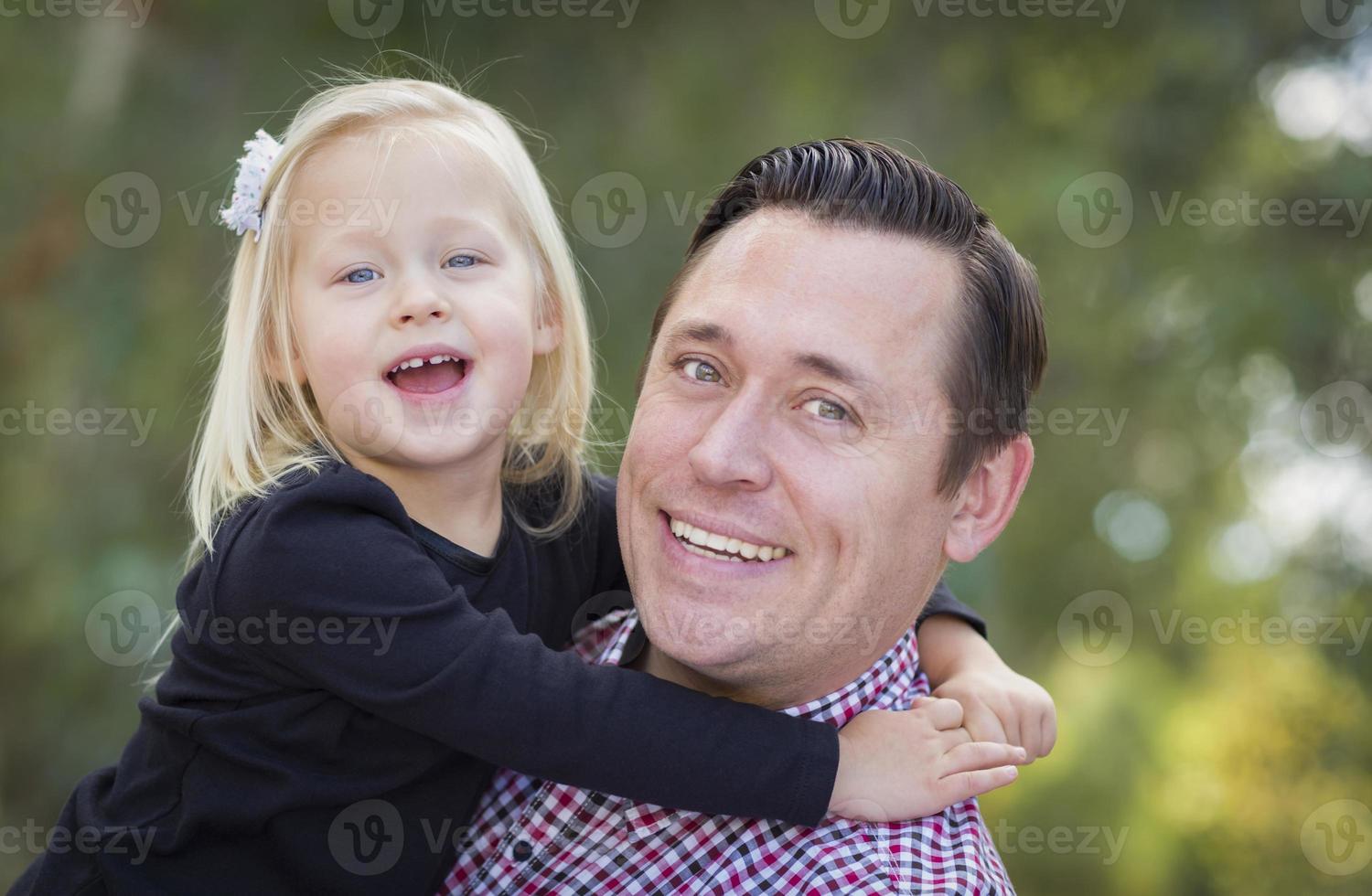 adorable niña divirtiéndose con papá al aire libre foto