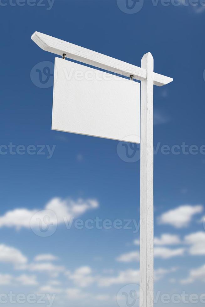 Blank Real Estate Sign Over A Blue Sky with Clouds. photo