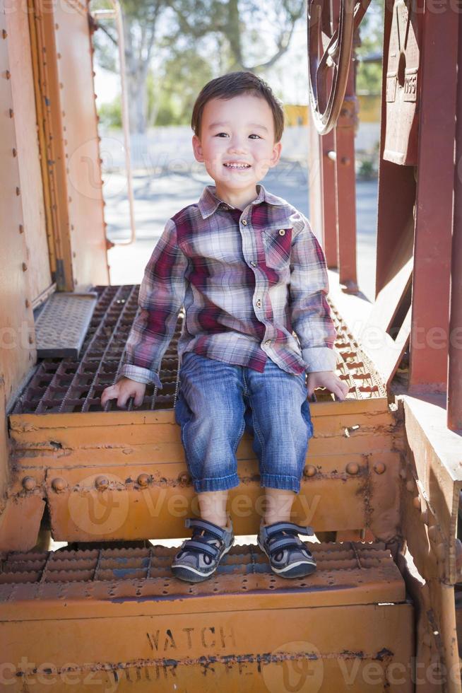 Cute Young Mixed Race Boy Having Fun on Railroad Car photo