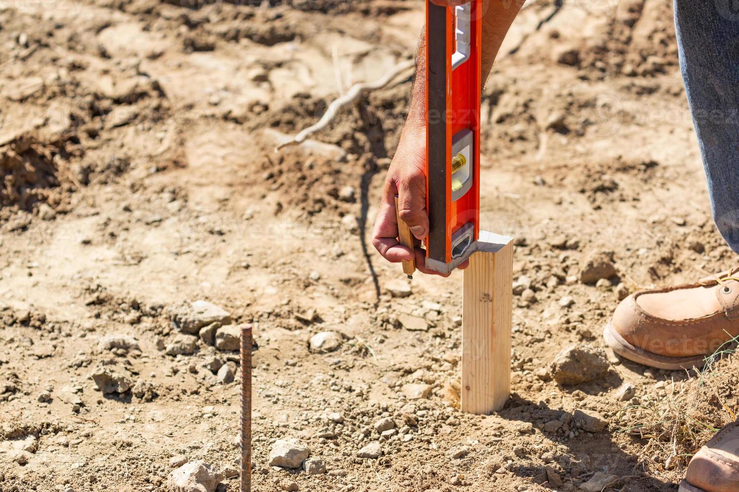 Worker Using Level At Construction Site photo