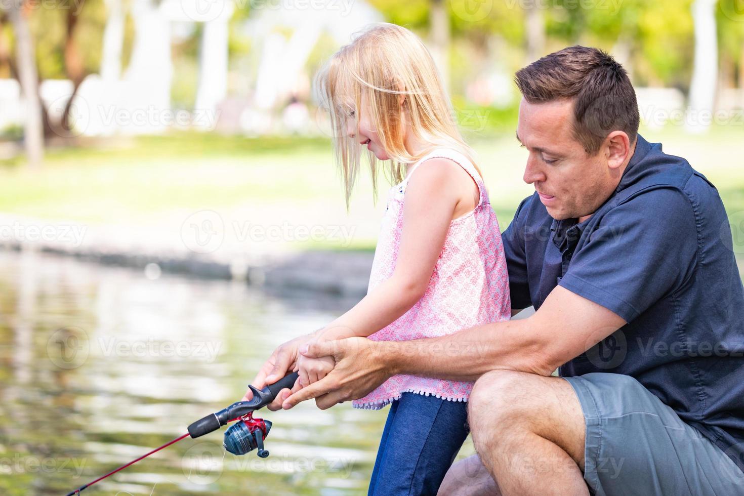 joven caucásico padre e hija divirtiéndose pescando en el lago foto